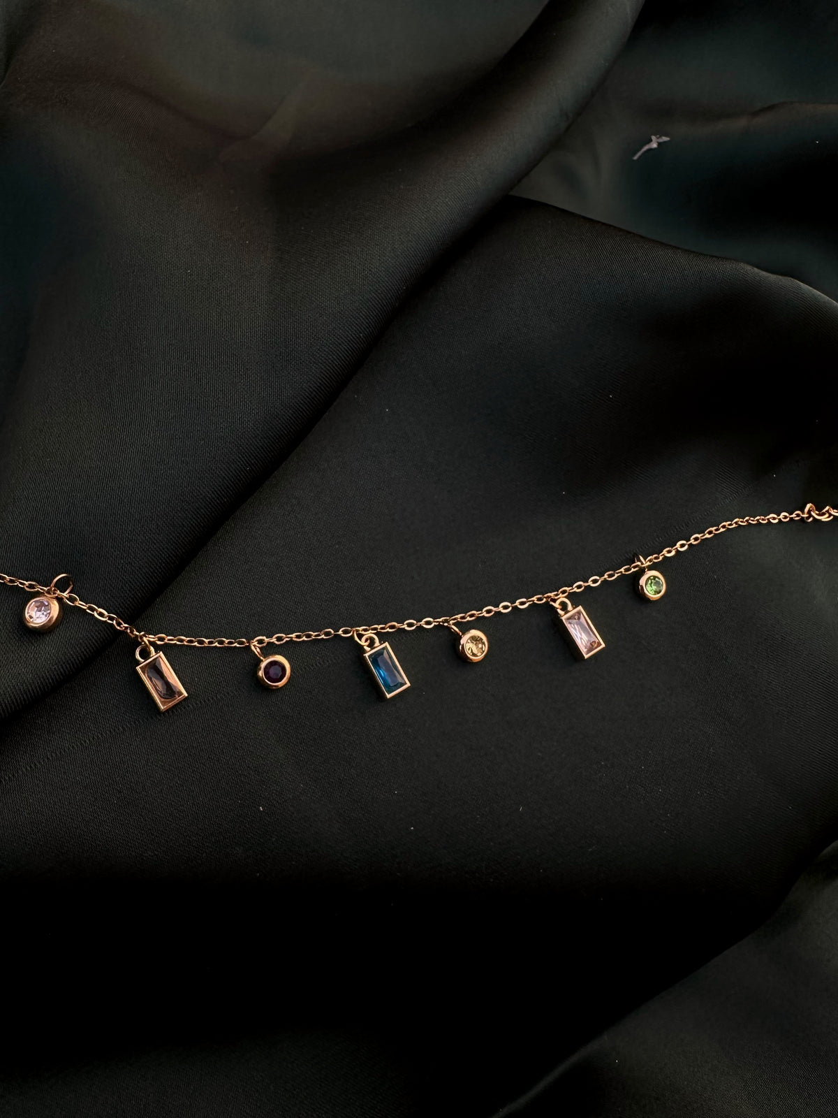 Crystal Charm Necklace on dark green silk