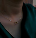 Infinite Love Necklace worn at the neckline over a deep green top