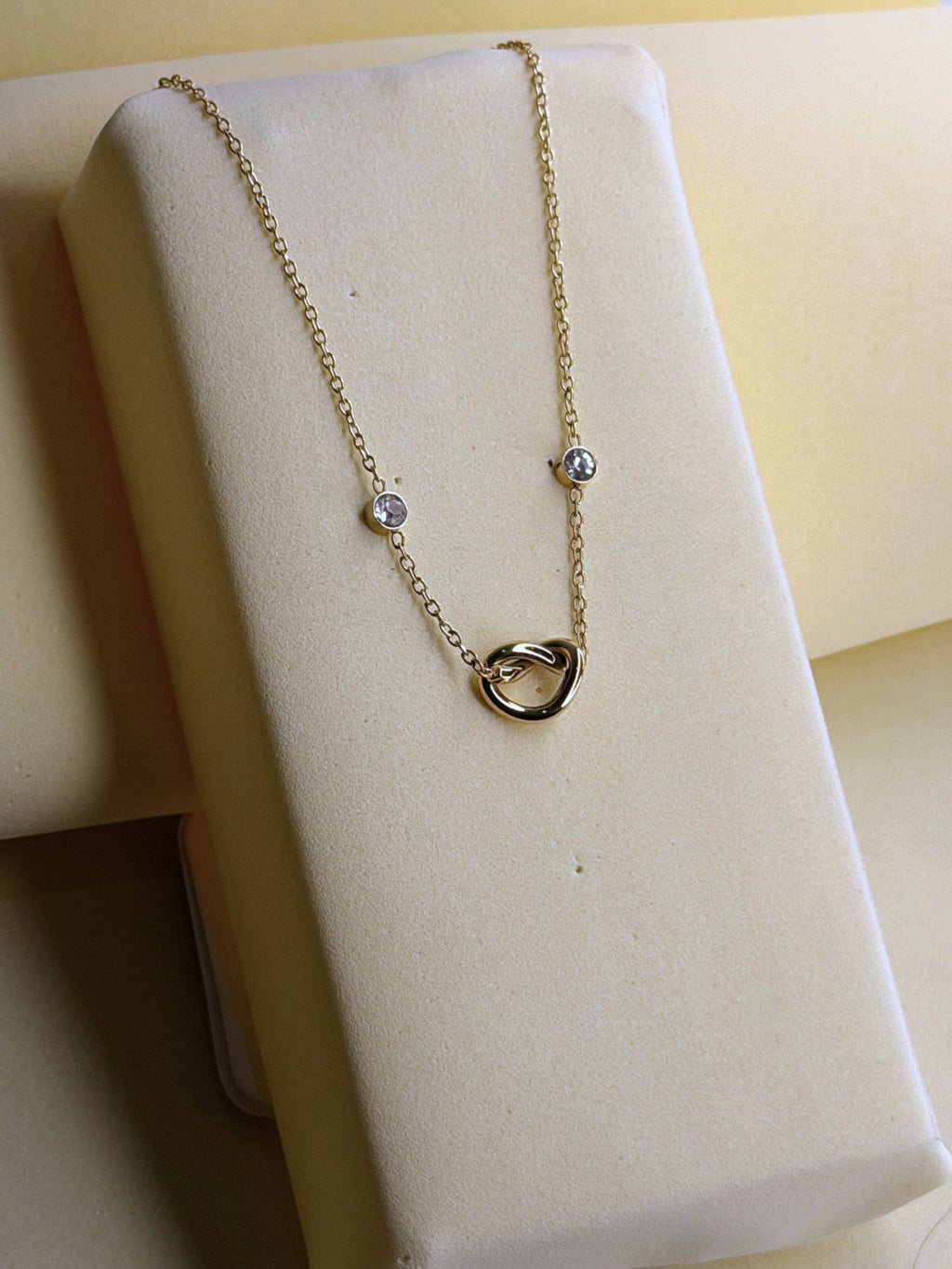 Infinite Love Necklace shown close up on a cream backdrop